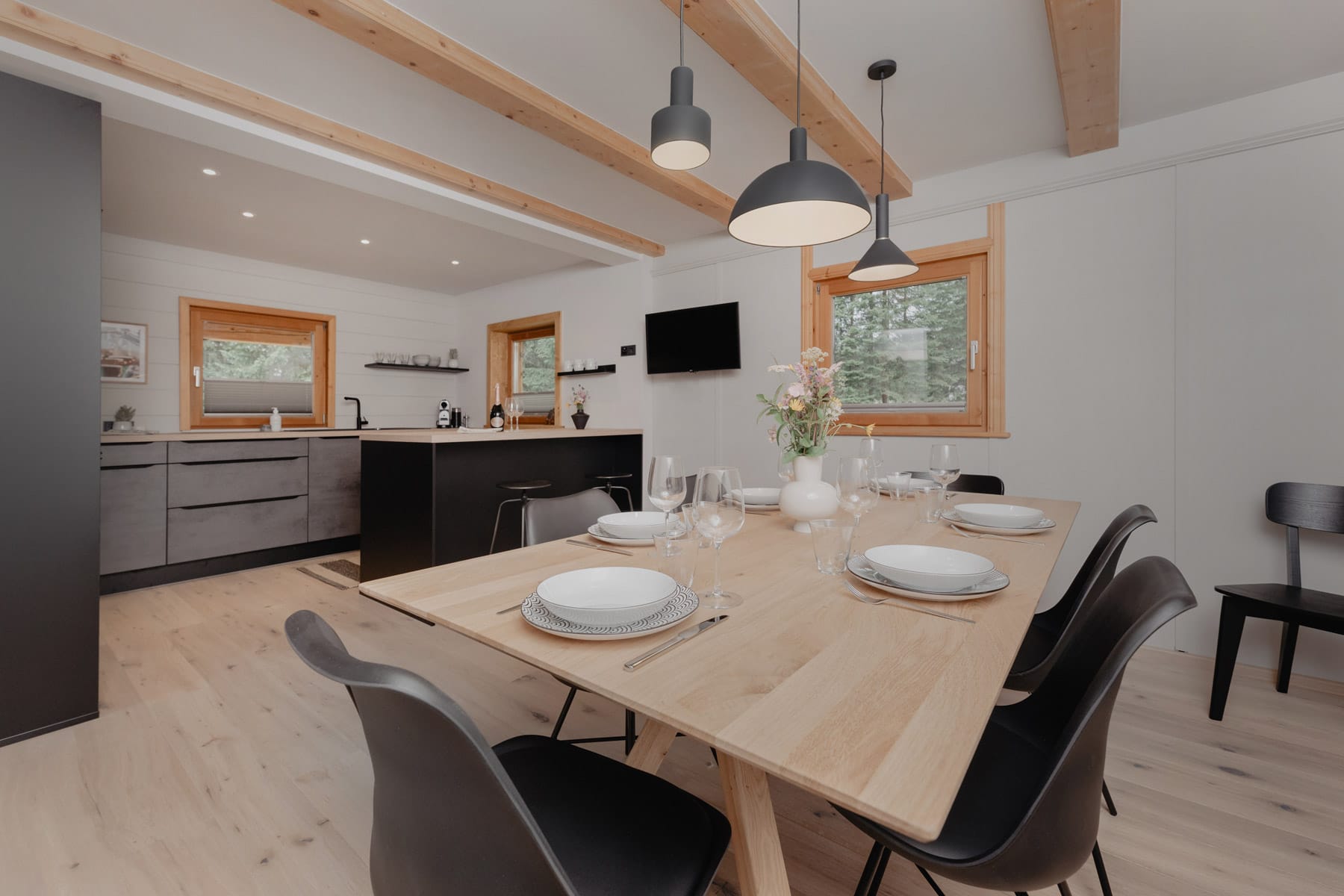 Helle Wohnküche mit Holzboden, gedecktem Esstisch und offener Küche
